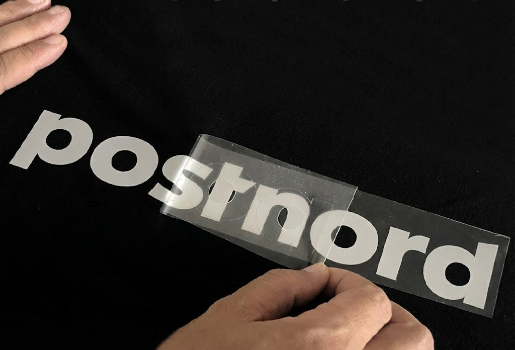 Positioning a reflective HTV logo on fabric before heat pressing