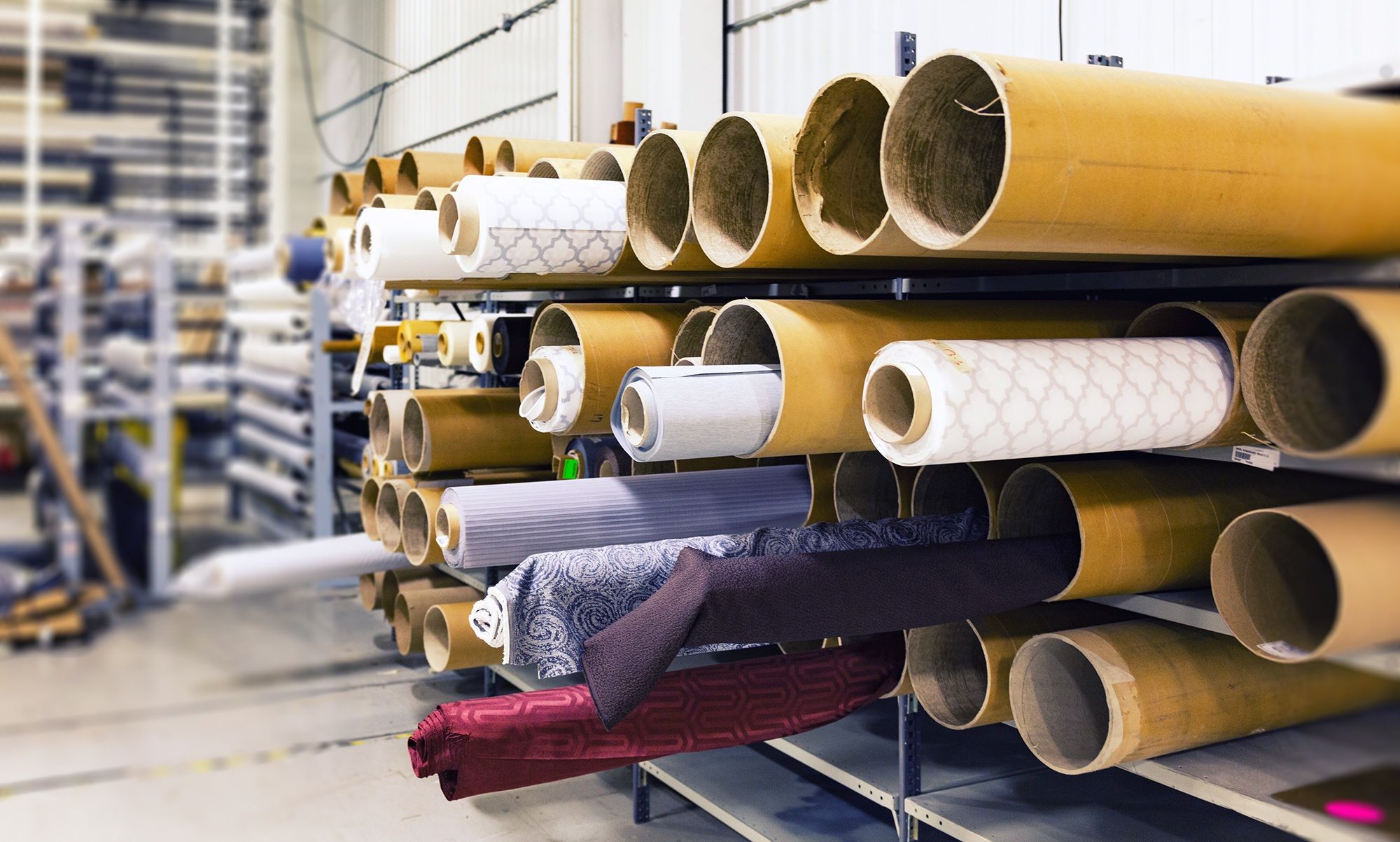 Rolls of fabric stored on racks in a textile warehouse