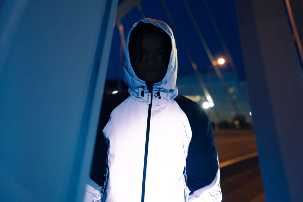 Hooded jacket made from silver reflective fabric glowing at night